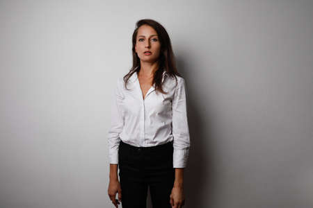 Portrait of young business woman posing isolated over grey wall background. Space for text.の写真素材