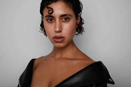Sexy woman with wet tousled dark hair and bright makeup, short hair, beauty and hair care.