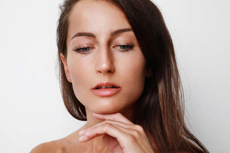 Beautiful woman cosmetic natural make up hand touching skin beauty model face white background.