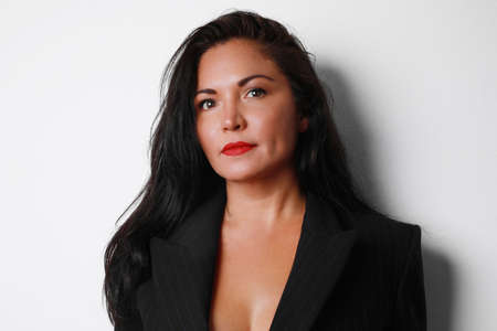 Portrait of attractive woman with long hair, posing over white background wall.