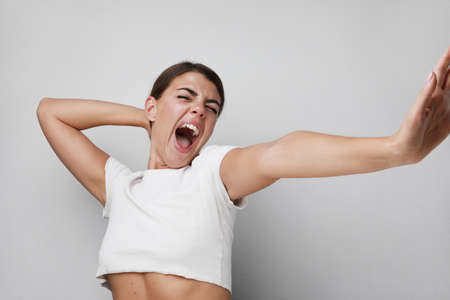 headshot of happy and young woman with hands up. Isolated on white background.
