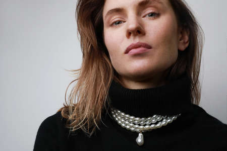 Close-up of young caucasian woman, isolated on light background.