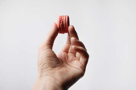 Human hand holding crunchy delicious macaron. Space for text.の写真素材