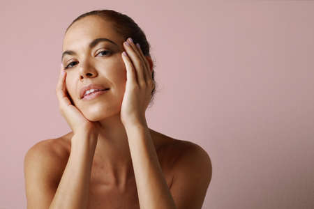 Beautiful mature woman with perfect skin smiling posing over white wall.の写真素材