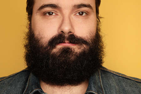 Portrait of large bearded man on yellow background. Close-up.の写真素材