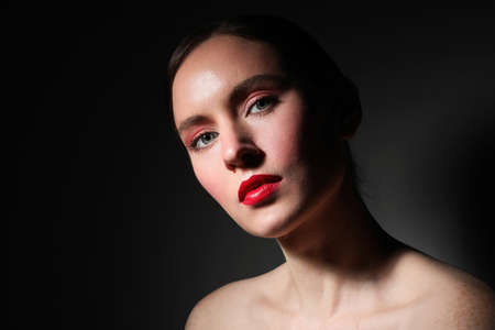 Beauty portrait of young woman, posing over black background.の写真素材