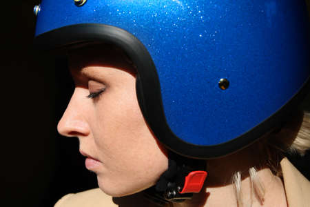 Close-up of young woman posing with blue retro helmet.の写真素材