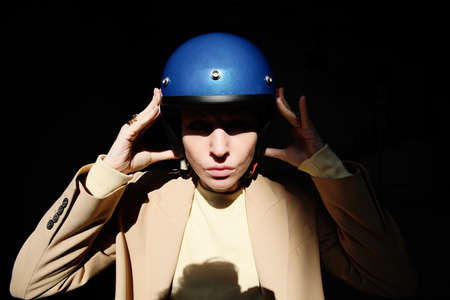 Young bikerwoman posing with blue retro helmet. Outdoor.の写真素材