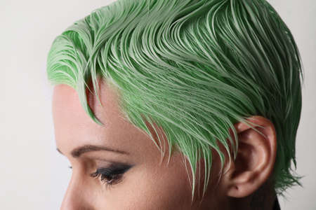 Cropped portrait of blond young woman with short green hair. Space for text.の写真素材
