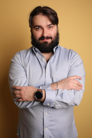 Confident big man with beard, posing over yellow background. Isolated.の写真素材