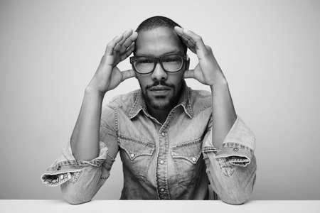 Black young man with glasses posing isolated in studio. Black and white.の写真素材