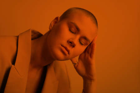 Portrait of beautiful bald woman with closed eyes. Dreaming girl. Orange fill.の写真素材