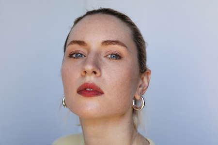 Thoughtful caucasian young woman, posing over white background.の写真素材