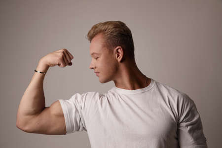 Muscular young man showing off his defined biceps. Life style and bodybuilding.の写真素材