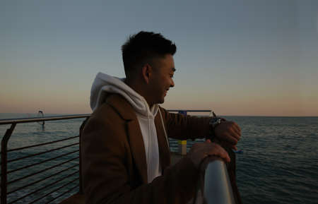 Silhouette of asian man standing against nature landscape in deep thoughtの写真素材