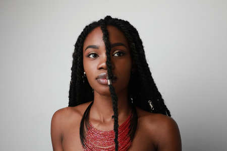 Confident black African young woman with braids, isolated.の写真素材