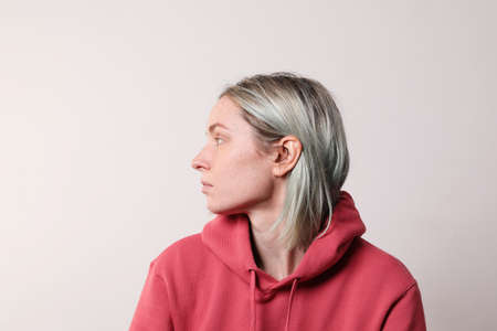 Side portrait of young happy woman with colourful hair posing in the studio.の写真素材