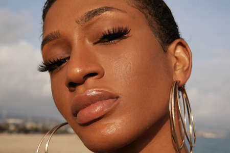 Close-up of beautiful black confident woman with short hair posing outdoor.