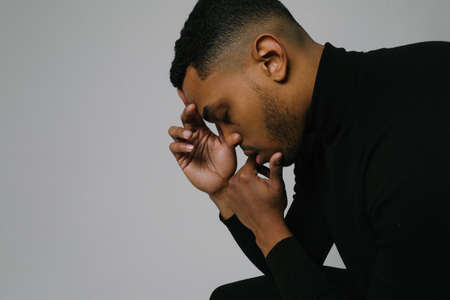 Side-view portrait of young Black man stressing and headache. Mental issues.の写真素材
