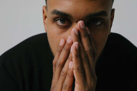 Close-up of young Black guy stressing and headache. Mental issues.の写真素材