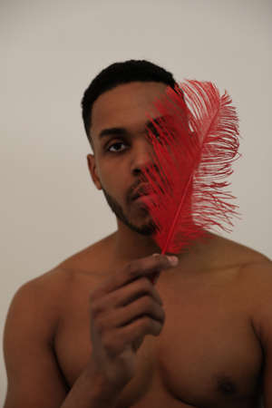 Close-up of American Indian warrior. Young man with red feather. Isolated.の写真素材