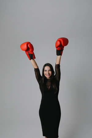 Middle age attractive woman won a boxing fight, hands up, her victory. Vertical.