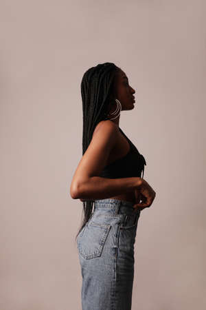 Side-view portrait of young black afro woman with long braids. Vertical.