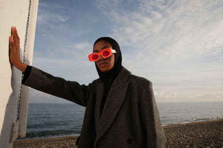 Outdoor portrait of fashionable young woman wearing big sunglasses.