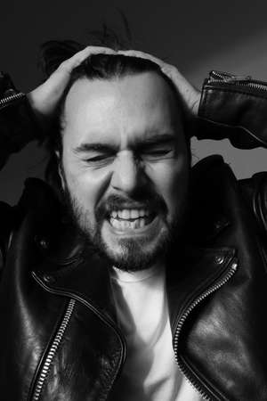 Black and white photo of bearded screaming brutal man. Vertical.