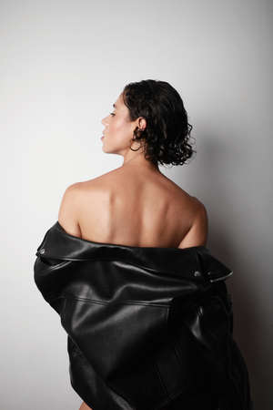 Back view of young proud woman posing on white background. Isolated.
