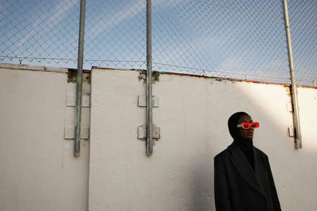 Fashionable black young woman wearing big sunglasses posing outdoor.