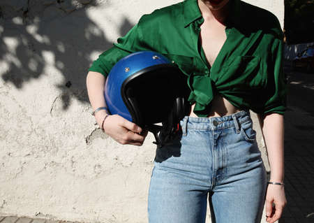 Cropped photo of woman outdoor holding motorcycle retro helmet. space for text.