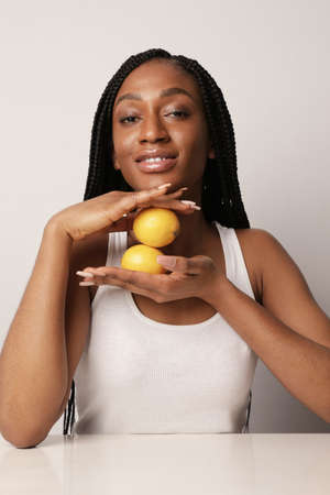 Young woman with fruits lemon. Energy from fruits, health and vitamins.の写真素材