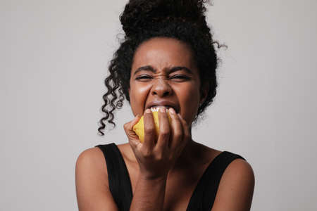 Cropped photo of woman posing with lemon on white wall for skin and body careの写真素材