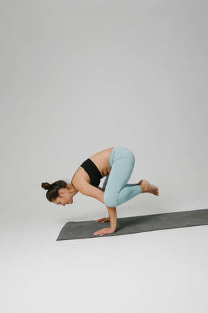 Portrait of woman practicing yoga asana in class. Calmness and relax. Vertical.