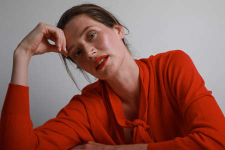 Pretty young woman looking at the camera, posing on withe background in studio.の写真素材