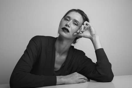 Young woman looking at the camera, posing on withe background. Black and white.の写真素材