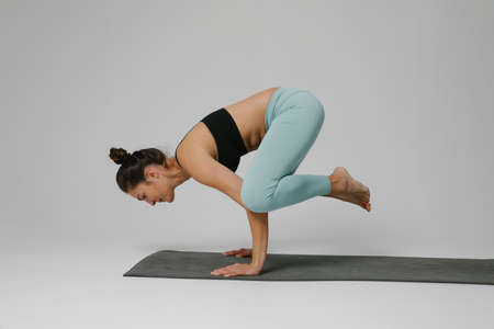 Young woman practicing yoga asana in class. Calmness and relax. Vertical.