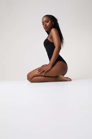 Vertical portrait of confident young woman with perfect body posing indoors.の写真素材