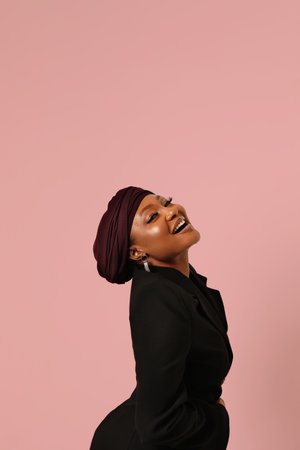 Muslim black young woman wearing hijab and posing on pink background. Mock-up.の写真素材