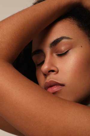 Close-up portrait of young woman with afro hair smiling with white wall.の写真素材