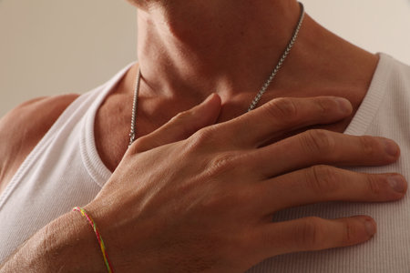 Mental health and mindset. Male hand over his chest indoor. Close-up.