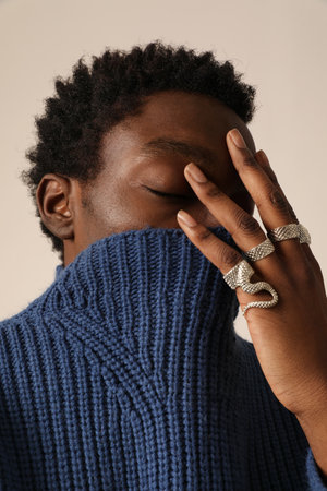Sad young man with closed eyes posing indoor. Vertical mock-up.の写真素材