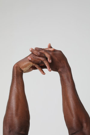 Rear view of healthy young man with arms stretched out. Vertical.