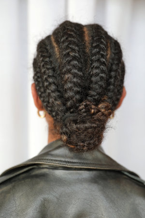 Cropped portrait of pretty young woman with braids back view. Vertical mock-up.
