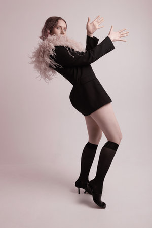 Studio portrait of stylish woman posing over white wall. Vertical mock-up.の写真素材