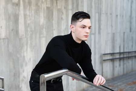 Handsome stylish young man posing in the street looking away. Mock-up.の写真素材