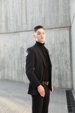 Handsome smiling stylish hipster young man. Fashion male posing outdoor.の写真素材