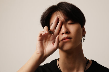 Close-up of young asian man posing on the white wall. Mental health issues.の写真素材