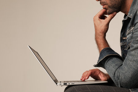 Cropped portrait of man working with laptop while sitting indoor. Mock-up.の写真素材